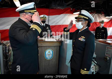 US Navy Cmdr. Matthew R. Shellock, links, begrüßt den ankommenden Kommandanten Cmdr. Ladonna M. Simpson vom Amphibiendock-Landungsschiff USS Carter Hall der Harpers Ferry-Klasse während einer Zeremonie zur Änderung des Kommandos am 21. Januar 2021 in Virginia Beach, Virginia. Stockfoto