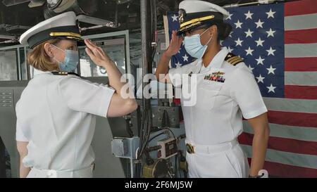 US Navy Cmdr. Kimberly Jones, der neue Kommandant des Docks der Whidbey Island-Klasse USS Tortuga, begrüßt den scheidenden Cmdr. Rosie Goscinski während der Befehlswechselzeremonie am 16. Juli 2020 in Virginia Beach, Virginia. Stockfoto