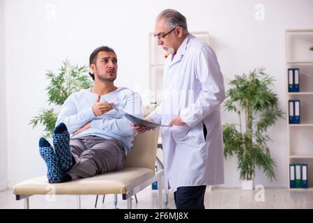 Kranker Mann besucht alten Arzt Radiologen Stockfoto