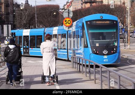 Stockholm, Schweden - 1. April 2021: Blaue, moderne Straßenbahn im Einsatz, die zur Djurgarden-Brücke nach Valdermarsudde fährt. Stockfoto