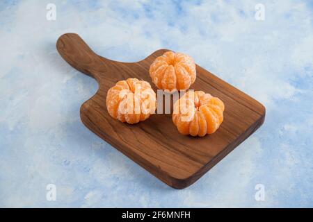 Nahaufnahme von drei geschälten Mandarinen Stockfoto