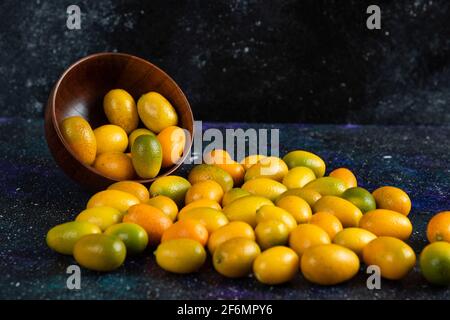 Haufen frischer Saft Kumquats auf blauem Hintergrund Stockfoto