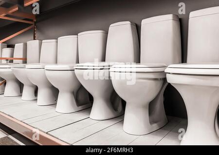 Eine Auswahl neuer moderner weißer Toiletten in einem Baumarkt. Stockfoto