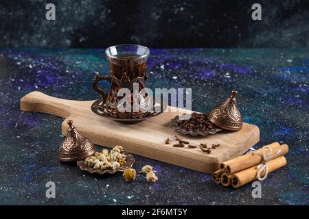 Verschiedene Kräuter mit heißem Tee in Holzbrett Stockfoto
