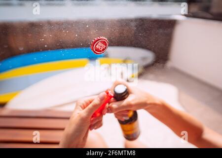 Öffnen einer Flasche Superbock-Bier mit explodierenden und spritzenden. Konzentrieren Sie sich auf die Kappe. 31.03.2021, Costa Da Caparica, Portugal Stockfoto