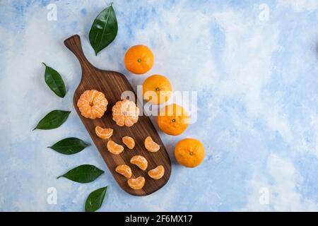 Frisch geschält und ganze Mandarine auf Holzschneidebrett Stockfoto