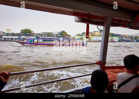 Vorbei an einem traditionellen thailändischen Langboot auf dem Chao Phraya River in Bangkok, Thailand Stockfoto