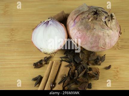 Alte Zwiebeln mit verschiedenen Gewürzen auf Holzplatte.Draufsicht Stockfoto