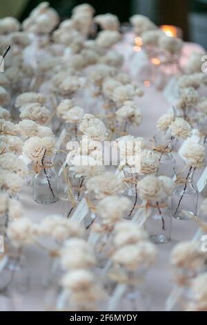 Weiche, weißrote Rosen in einem Glas als Namensschmuck tags in einem Hochzeitsempfang Stockfoto