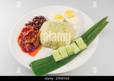 Nasi-Lemak mit Pandanreis (malaiisch duftendes Reisgericht in Kokosmilch und Pandan-Blatt gekocht) mit Rezepturzutaten. Die besten würzigen Sardellen lecker. Stockfoto