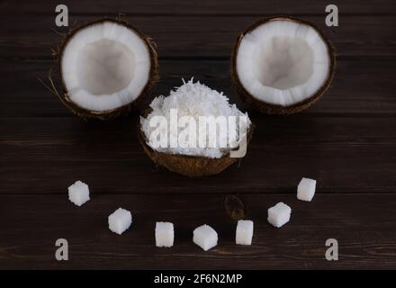 Split Kokosnuss auf Holzplanken. Selektiver Fokus. Nussschale ist mit Kokosraspeln gefüllt. Coco, reife Palmfrüchte. Stockfoto