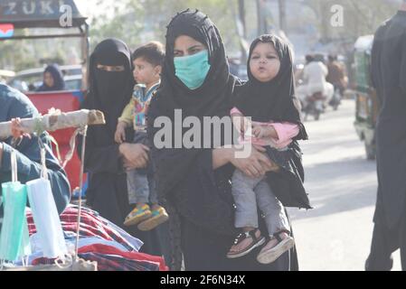 Lahore, Pakistan. April 2021. Pakistanische Familienmitglieder reisen zu Fuß, weil sie wegen der Schließung von Speedo-Bussen und der Orange Line Metro Train (OLMT) wegen neuer Beschränkungen, die die Ausbreitung des Covid-19 in der Provinzhauptstadt Lahore eindämmen, Schwierigkeiten haben. (Foto von Rana Sajid Hussain/Pacific Press) Quelle: Pacific Press Media Production Corp./Alamy Live News Stockfoto