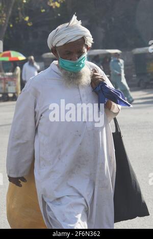 Lahore, Pakistan. April 2021. Pakistanische Familienmitglieder reisen zu Fuß, weil sie wegen der Schließung von Speedo-Bussen und der Orange Line Metro Train (OLMT) wegen neuer Beschränkungen, die die Ausbreitung des Covid-19 in der Provinzhauptstadt Lahore eindämmen, Schwierigkeiten haben. (Foto von Rana Sajid Hussain/Pacific Press) Quelle: Pacific Press Media Production Corp./Alamy Live News Stockfoto