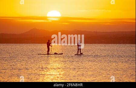 Portobello, Edinburgh, Schottland, UK Wetter. April 2021. Guter Sonnenschein für Karfreitag-Sonnenaufgang, Temperatur minus 1 Grad Celsius am Meer am Firth of Forth für die winterharten Kaltwasserschwimmer und Stand Up SUP Paddle Boarder. Stockfoto