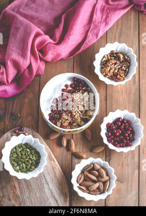 Gesunde Snacks. Vielfalt an Superfood: Nüsse, Beeren, Körner auf Holzgrund Stockfoto