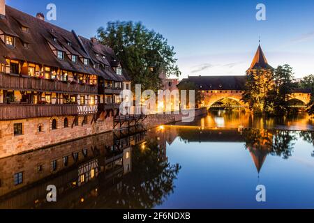 Ein farbenfroher und malerischer Blick auf die alten Fachwerkhäuser am Ufer der Pegnitz in Nürnberg, Franken, Deutschland, beleuchtet am ni Stockfoto