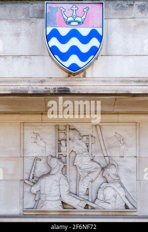 Steinreliefskulptur von Gilbert Bayes auf dem Lambeth Fire Brigade Building (1937), dem ehemaligen Hauptquartier der LFB, am Albert Embankment in London. Stockfoto