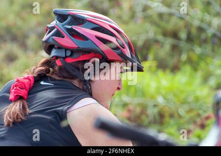 Radfahrerin in der Natur auf einem einspurigen Weg in einem Wald. Fotografiert in Israel im Februar Stockfoto