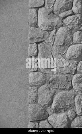 Ungerade geformte Steine oder Felsen passen zusammen wie ein Puzzle, um eine konstruierte Steinmauer Mauerwerk Haus Außenwand Hintergrund Hintergrund oder Tapete zu schaffen Stockfoto