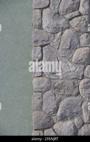 Ungerade geformte Steine oder Felsen passen zusammen wie ein Puzzle, um eine konstruierte Steinmauer Mauerwerk Haus Außenwand Hintergrund Hintergrund oder Tapete zu schaffen Stockfoto