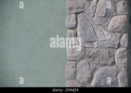 Ungerade geformte Steine oder Felsen passen zusammen wie ein Puzzle, um eine konstruierte Steinmauer Mauerwerk Haus Außenwand Hintergrund Hintergrund oder Tapete zu schaffen Stockfoto