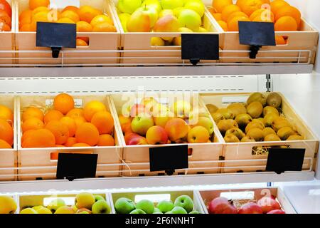 Vielfalt an verschiedenen Früchten Orangen, Kiwi, Äpfel, Granatäpfel auf Regalen im Supermarkt. Vitamine und Mineralstoffe. Stockfoto