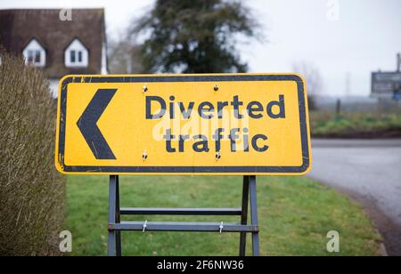 Umgelenkt Verkehrsschild mit Pfeil nach links. Gelbes Straßenschild in Großbritannien in Nahaufnahme, das eine Umleitung oder Umleitung anzeigt. Stockfoto