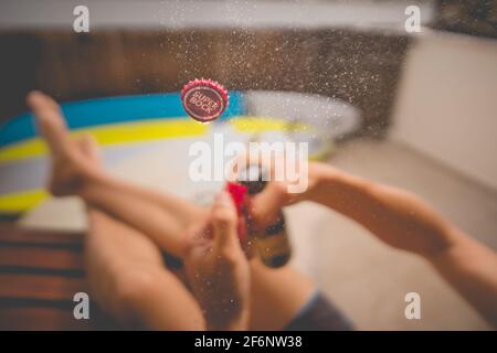 Öffnen einer Flasche Superbock-Bier mit explodierenden und spritzenden. Konzentrieren Sie sich auf die Kappe. Super Bock Bier trinken 31.03.2021, Costa Da Caparica, Portugal Stockfoto