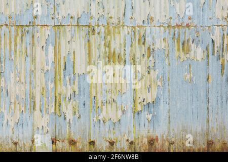 Wellblechdach, Wellblechplatten mit abblätternder Farbe. Grunge Textur, Muster oder Hintergrund, UK Stockfoto