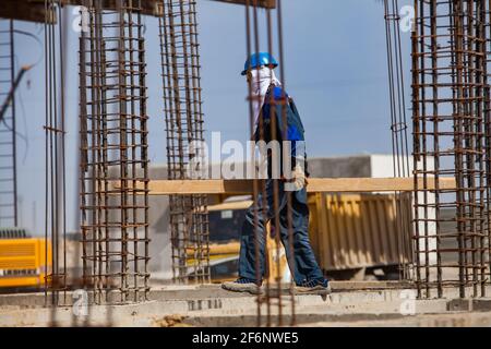 Aktau, Kasachstan - 19. Mai 2012 Bau einer modernen asphaltischen Bitumenanlage. Arbeiter in Balaclava Maske und Verstärkung Stahl und blauen Himmel auf dem Rücken Stockfoto