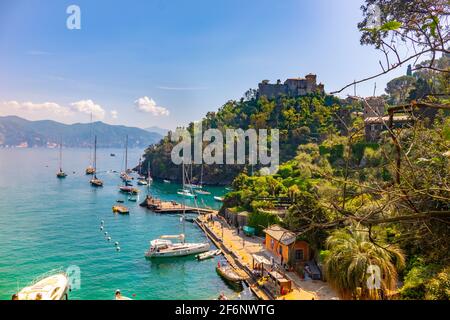 Schöne bunte Aussicht Golf von Portofino Italien mit Schloss Braun im Hintergrund und Boote zu kleinen malerischen Hafen verankert. Stockfoto