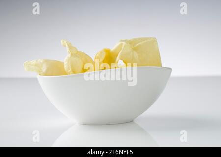 Papadium oder einfaches Pappadom oder Appalam, Hauptvorspeise für südindische Mahlzeiten in einer weißen Schüssel mit weißem strukturiertem Hintergrund. Stockfoto