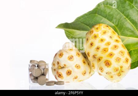 Morinda citrifolia - Noni Früchte und Pillen. Stockfoto