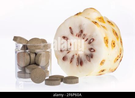 Morinda citrifolia - Noni Früchte und Pillen. Stockfoto