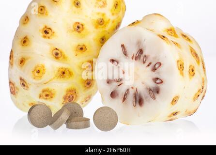 Morinda citrifolia - Noni Früchte und Pillen. Stockfoto