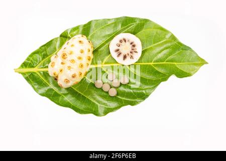 Morinda citrifolia - Noni Früchte und Pillen. Stockfoto