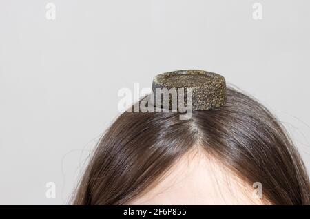 Eine Frau und ein solides Shampoo mit natürlichem Make-up. Umweltfreundliche Seife ohne Plastik und Verschmutzung. Stockfoto