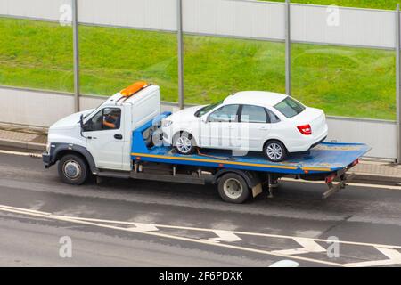 Abschleppdienst der Abschleppwagen mit dem beladenen alten beschädigt Auto, das nicht mehr funktioniert Stockfoto