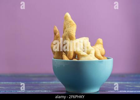 Italienische Frappe oder chiacchiere aus Weizenteig in einem Porzellantopf. Kulinarische Köstlichkeiten und Gaumenfreuden. Italienische Küche. Gebratener Weizenteig mit suga Stockfoto