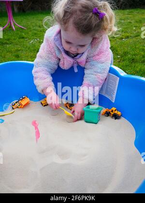 Kleinkind spielt in einer Sandgrube, Großbritannien Stockfoto