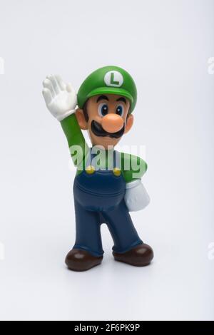 Moskau, Russland - 06. April 2021: Plastikfigur von Luigi aus Nintendo-Videospiel isoliert auf weißem Hintergrund. Stockfoto