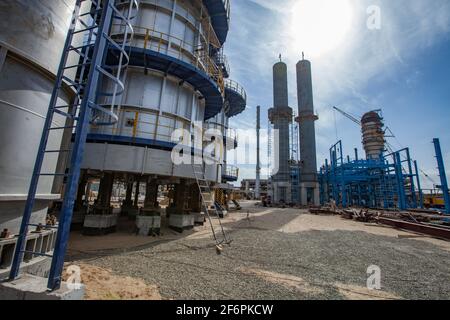 Aktau, Kasachstan-Mai 19,2012: Bau einer asphaltischen Bitumenanlage. Raffineriesäulen, Rauchstapel, Mobilkran und blaue Stahlkonstruktion. Stockfoto