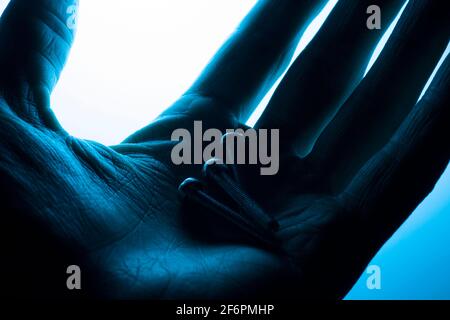 Schrauben in der Hand auf blauem Hintergrund Stockfoto