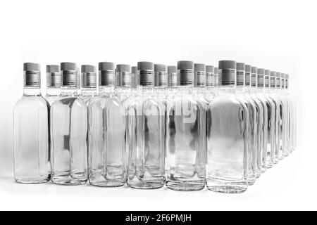 Eine Vielzahl von reinen Alkoholflaschen, die nicht gekennzeichnet sind. Flaschen von alkoholischen Getränken zu Hause isoliert auf Weiß. Herstellung kleiner Laugen auf Basis der Destillation. B Stockfoto