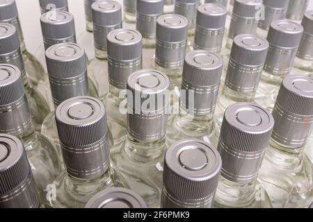 Eine Vielzahl von reinen Alkoholflaschen, die nicht gekennzeichnet sind. Flaschen von alkoholischen Getränken zu Hause isoliert auf Weiß. Herstellung kleiner Laugen auf Basis der Destillation. B Stockfoto