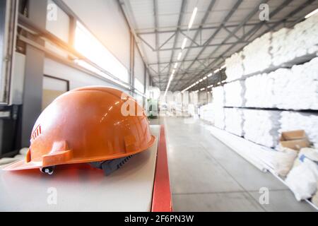 Schützende orange Hut Nahaufnahme auf dem Hintergrund von Innenräume von Industriefabriken Stockfoto