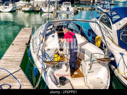 Jet washing eine Yacht in Vorbereitung auf die Segel, Ocean Village Marina, Southampton, UK Stockfoto