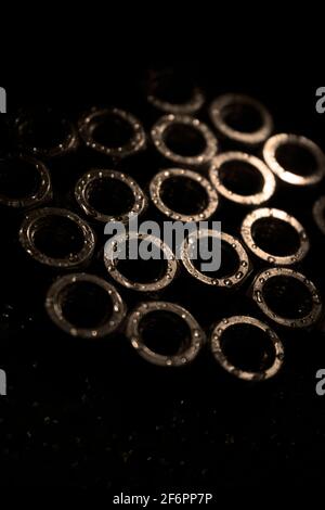 Schraubenmuttern mit Wassertropfen auf einer dunklen Oberfläche Stockfoto