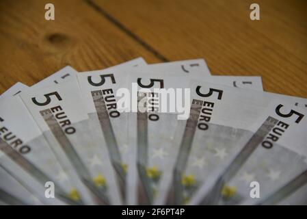 deutsche Euro-Banknoten auf dem Boden mit verschiedenen Gegenständen wie einer Brieftasche, einer Maske oder einer Schatzkiste Stockfoto