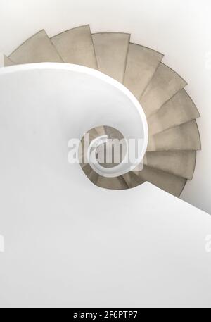 Wendeltreppe mit schlichten weißen Geländern und Wänden. Reiner Minimalismus. Stockfoto